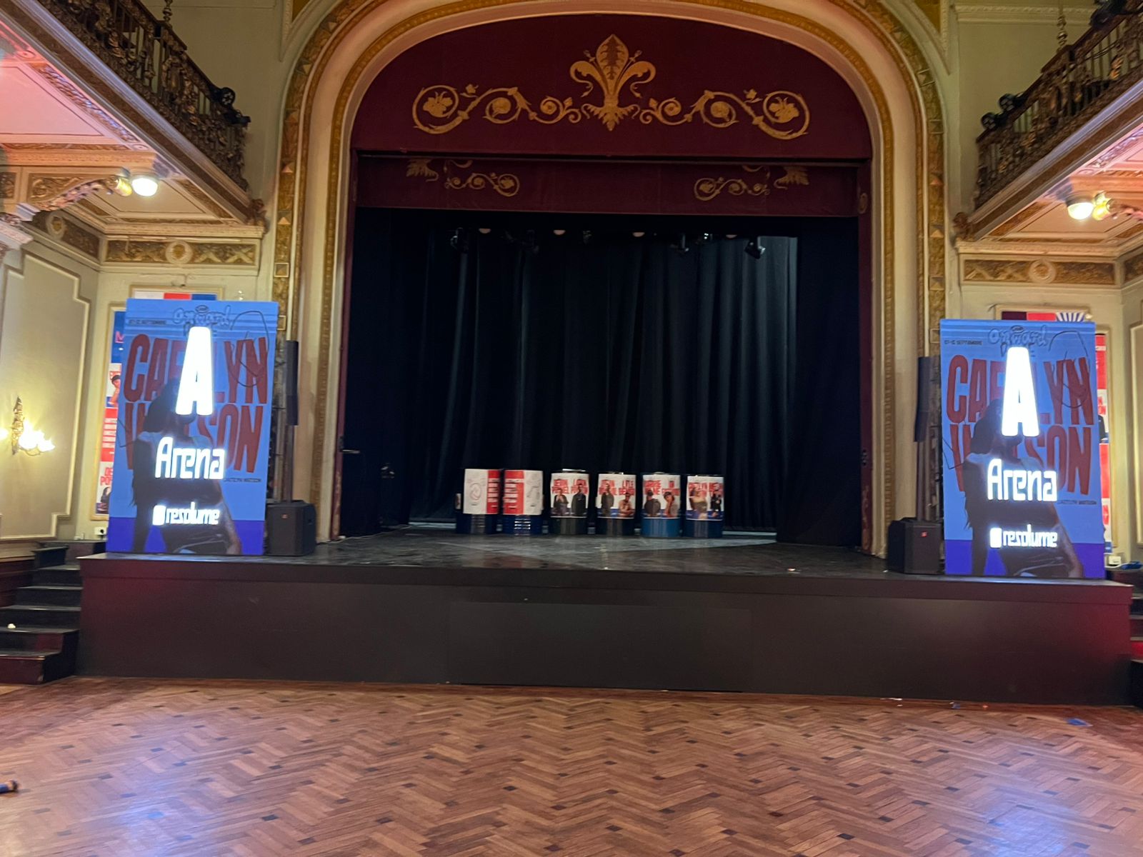 Two illuminated vertical LED displays on either side of a theater stage.