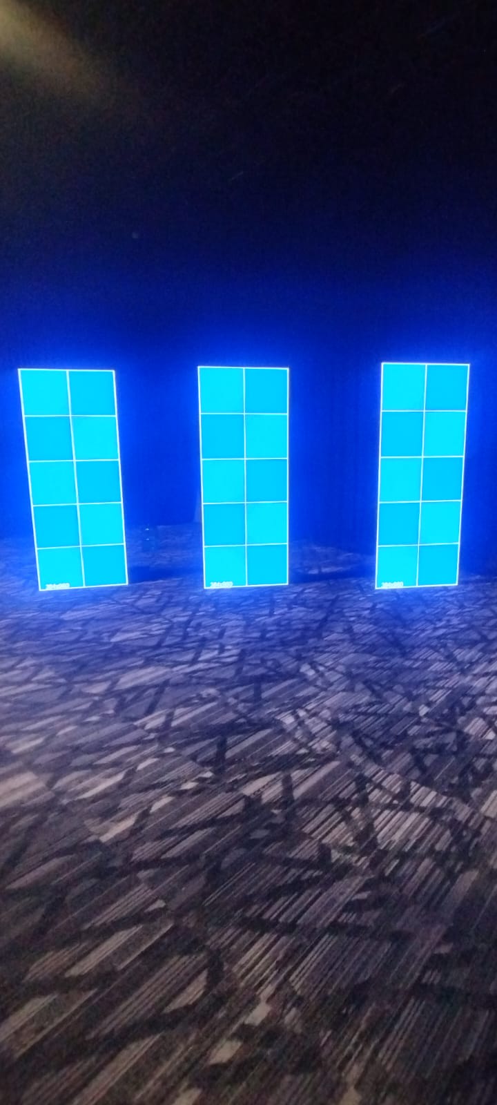 Tres tótems LED verticales separados entre sí, mostrando cuadrículas de prueba.